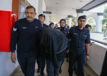 ANGGOTA polis mengawal tertuduh yang berhadapan pendakwaan melakukan amang seksual fizikal di Mahkamah Sesyen Alor Setar, hari ini. - UTUSAN/ SHAHIR NOORDIN