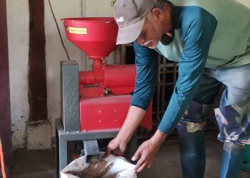 ABDULLAH Harun menunjukkan mesin mengisar padi untuk menghasilkan beras di kediamannya di Sungai Manik di Pasir Salak. - UTUSAN/AIN SAFRE BIDIN