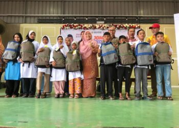 DR. Hafidzah Mustakim (tengah) bersama penerima kelengkapan sekolah pada Program Jom Ke Sekolah di Sekolah Kebangsaan Tengku Indera Petra, Kota Bharu, Kelantan, hari ini. - UTUSAN/ ROSLIZA MOHAMED