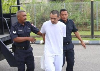 HAFIZUL Hawari diiringi polis semasa menghadiri prosiding perbicaraan di Mahkamah Sesyen Kota Bharu, Kelantan.