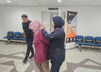 ROSNURDALILA Yusop (tengah) yang dituduh mencuri di sebuah pasar raya dibawa keluar dari Mahkamah Majistret Kuala Terengganu - UTUSAN/ZAID MOHD.NOOR