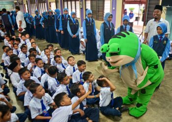 MURID tahun satu hingga enam disambut mesra  maskot memakai kostum katak pada hari pertama sesi persekolahan di Sekolah Kebangsaan Bukit Sawa, Marang, Terengganu, hari ini. - UTUSAN/PUQTRA HAIRRY