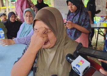 NORHAYATI Ramlly tidak dapat menahan sebak ketika ditemui pemberita selepas anaknya, Muhammad Naufal Aiman dikhuatiri lemas dihanyutkan arus Sungai Perak di Kampung Tepus, Parit di sini hari ini. - UTUSAN