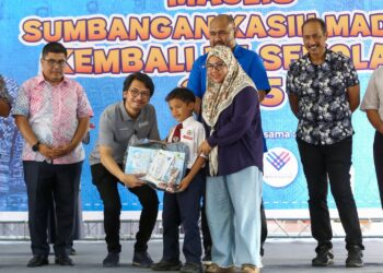 MUHAMMAD Kamil Abdul Munim menyampaikan sumbangan kelengkapan persekolahan pada program di SMK Simpang Beluru  di Padang Rengas hari ini. - UTUSAN/MUHAMAD NAZREEN SYAH MUSTHAFA