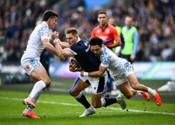 Pemain sayap Scotland, Duhan van der Merwe (tengah) cuba melepaskan diri daripada dua pemain Itali dalam saingan ragbi enam negara di  Stadium Murrayfield,  Edinburgh. - AFP