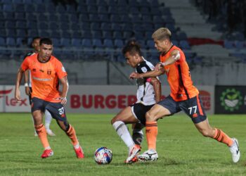 SAFAWI Rasid (tengah) diasak dua pemain Kuching City FC dalam perlawanan Liga Super di Stadium Sultan Mizan Zainal Abidin, Gong Badak, Kuala Nerus, Terengganu, malam ini. - UTUSAN/PUQTRA HAIRRY ROSLI