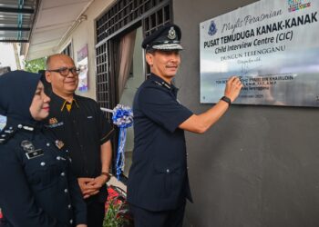 MOHD. Khairi Khairudin (kanan) menurunkan tanda tangan pada plak pada Majlis Perasmian Pusat Temuduga Kanak-Kanak (CIC) di Jalan Teluk Lipat, Dungun, Terengganu. - UTUSAN/PUQTRA HAIRRY