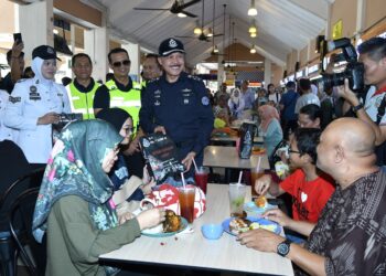 MOHD. Yusri Hassan Basri (tengah) beramah mesra bersama pengguna lebuh raya pada Program Advokasi Op Selamat 23 Sempena Tahun Baharu Cina 2025 di Hentian Rehat dan Rawat (RNR) Tapah Arah Selatan, Tapah hari ini. - UTUSAN/ZULFACHRI ZULKIFLI