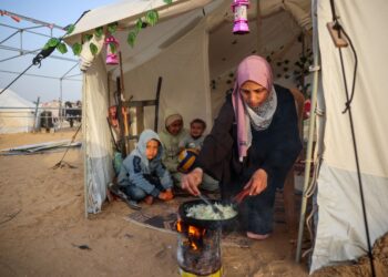 SEORANG wanita Palestin menyediakan juadah berbuka puasa untuk anak-anaknya di dalam khemah penempatan di tengah Semenanjung Gaza. – AFP