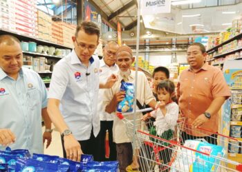 MOHD. FARED Mohd. Khalid (dua dari kiri)  membantu sebuah keluarga asnaf berbelanja sempena program Dapur Asnaf di sebuah pasar raya di B5, Bandar Baru Uda, Johor Bahru.