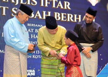 KETUA Menteri, Datuk Seri Hajiji Noor (tengah) dan Anifah Aman (kiri) semasa penyampaian sumbangan kepada anak yatim sempena Majlis Iftar Invest Sabah Berhad di Kota Kinabalu, semalam.