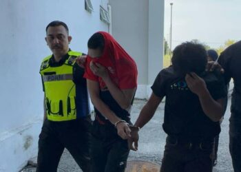 DUA  tertuduh kes rompak diiringi polis semasa hadir untuk prosiding perbicaraan di Mahkamah Sesyen Kota Bharu, Kelantan.- UTUSAN/ROSALWANI CHE SOH