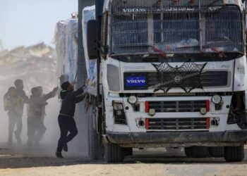 KANAK-kanak Palestin cuba menarik bungkusan bantuan kemanusiaan daripada sebuah trak ketika melalui Rafah di selatan Gaza dari persimpangan Kerem Shalom, pada 18 Februari lepas. – AFP