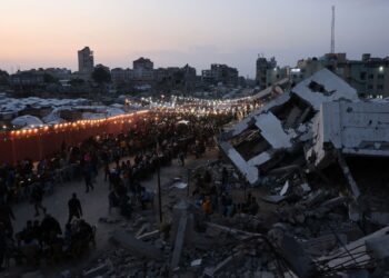 PENDUDUK Palestin berkumpul di tengah runtuhanbangunan untuk berbuka puasa
beramai-ramai di Gaza City, pada 6 Mac lepas.- AFP