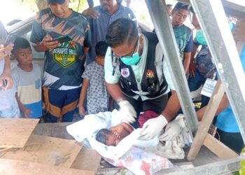 PEGAWAI perubatan memeriksa bayi yang ditemui penduduk di bangsal kayu di Lorong 1, Taman Semarak Sungai Petani.