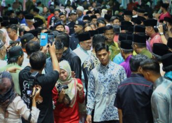 ANWAR Ibrahim bersalaman dengan hadirin pada majlis berbuka puasa di Padang Serbaguna Tampin hari ini.-UTUSAN/MOHD. SHAHJEHAN MAAMIN.