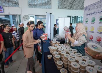 AGIHAN bubur lambuk dan produk Mahsuri diedarkan selepas selesai solat Jumaat di Kompleks Islam Tuanku Muhriz, USIM, Nilai, Seremban, Negeri Sembilan.