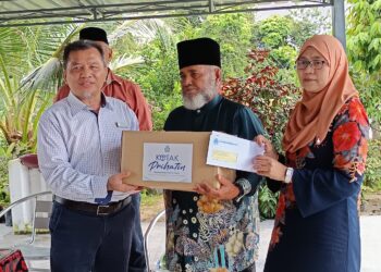 WAN Kefli Hamid (kiri) menyerahkan sumbangan faedah Perkeso kepada waris keluarga Allahyarham Mohd. Azam di Kampung Batang Rokan, Gemencheh, Tampin hari ini. - UTUSAN/NOR AINNA HAMZAH