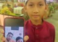 HARRAZ Zharfan Khan menunjukkan gambar kenangan bersama arwah bapanya pada Majlis Berbuka Puasa dan Sumbangan Duit Raya kepada anak-anak yatim dan asnaf, anjuran Majlis Datuk Datuk Negeri Melaka (MDDNM) di sebuah hotel di Ayer Keroh, malam semalam. UTUSAN/AMRAN ALI