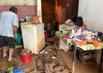 MANGSA banjir di Kampung Maju Jaya, Johor Bahru membersihkan rumah masing-masing setelah banjir surut