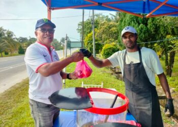 MOHAMMAD Gopi Rizqi melayan pelanggan yang datang membeli air balang di gerainya di Kampung Api-Api, Pontian, Johor.