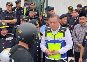 ANTHONY Loke Siew Fook bertanya sesuatu kepada seorang penunggang motosikal ketika operasi di Stesen Penguat Kuasa JPJ Semenyih, Selangor.