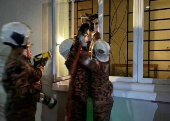 ANGGOTA bomba membuka tingkap untuk masuk ke dalam rumah berkunci di mana seorang lelaki warga emas ditemukan meninggal dunia di Jalan Tasik Botani, Ipoh semalam. - UTUSAN