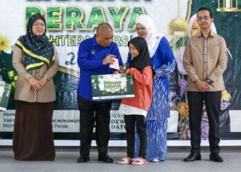 SAARANI Mohamad menyampaikan sumbangan kepada penerima pada program Meriah Beraya Sejahtera Bersama di Bidor hari ini. - UTUSAN/MUHAMAD NAZREEN SYAH MUSTHAFA