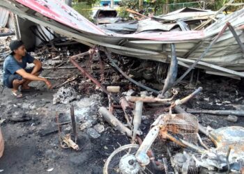 MOHD. Firdaus Zamri melihat motosikal pelanggan yang musnah selepas bengkel miliknya terbakar di Kampung Sri Tanjung, Pasir Pekan, Tumpat, Kelantan. - UTUSAN./ROHANA MOHD.NAWI