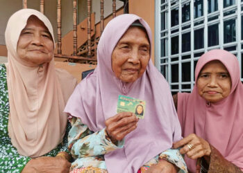 ATIMAH Narijan (tengah) bersama dua anaknya ketika ditemui di Kampung Tanjung Sari, Teluk Bharu di Teluk Intan. – UTUSAN/AIN SAFRE BIDIN.