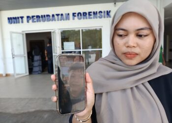 ROSALIAH Diego, 26, menunjukkan gambar Muhammad Aidil Ramdan Abdullah, 15, ketika ditemui di pekarangan Unit Perubatan Forensik Hospital Rembau, semalam. – UTUSAN/NOR AINNA HAMZAH.