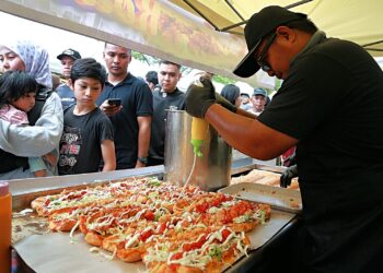 MOHD. Helmi Roslan tekun menyiapkan tempahan pembeli di Bazar Ramadan Metropark Sendayan, Seremban, Negeri Sembilan. – UTUSAN/MOHD. SHAHJEHAN MAAMIN