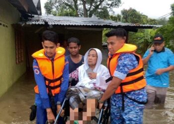 APM memindahkan seorang mangsa banjir di Kampung Si Rusa iaitu warga emas wanita berusia 70an ke PPS Kampung Sawah Sunggala, di sini, pagi tadi. -IHSAN APM