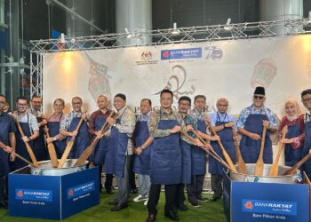 AHMAD Shahril Mohd. Shariff (enam dari kiri) mengacau bubur lambuk sebagai gimik pelancaran Program Bubur Lambuk 2025 di Menara Berkembar Bank Rakyat, Kuala Lumpur, hari ini. - UTUSAN/ANEES RAUDHAH AZMAN