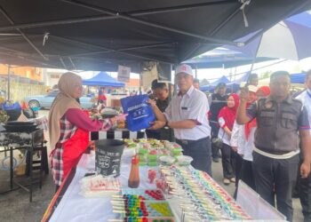 ZAINI Hussin (kanan) beramah mesra bersama peniaga bazar pada Program Walkabout di Bazar Ramadan Dataran Kenanga Machang,Kelantan. UTUSAN/ROSMIZAN RESDI