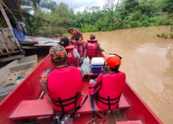 PASUKAN Bomba melakukan operasi pemindahan mangsa banjir di Tenom semalam.