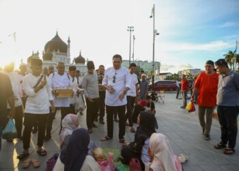 MUHAMAD Akmal Saleh menyantuni dan menyampaikan makanan kepada orang ramai sempena Majlis Iftar Bersama Pemuda UMNO di Dataran Medan Bandar, Alor Setar semalam. - UTUSAN/ SHAHIR NOORDIN