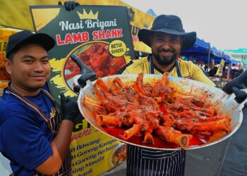 SALMAN SALIH Shuaib (kanan) menunjukkan lamb shank yang dijual di Bazar Ramadan Batu 4, Port Dickson, Negeri Sembilan. – UTUSAN/MOHD. SHAHJEHAN MAAMIN