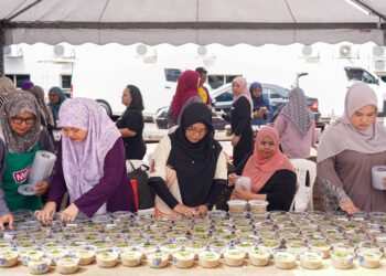 Kakitangan Fakulti Komunikasi dan Pengajian Media UiTM Shah Alam serta Media Mulia menutup bekas bubur lambuk yang akan diedarkan  kepada orang ramai sebagai juadah berbuka di Shah Alam, semalam. - UTUSAN/ISKANDAR ISHAK