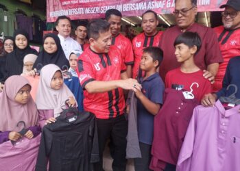 TUN Faisal Ismail Azizi diiringi Mohamad Hanifah menyantuni anak-anak asnaf dalam Program Membeli Belah Baju Raya Asnaf di Nilai, Seremban hari ini.- UTUSAN/NUR SHARIEZA ISMAIL