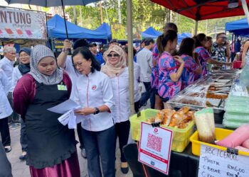 MARIA Suleiman (tengah) memberi penerangan ringkas mengenai keselamatan makanan kepada salah seorang peniaga di Bazar Ramadan Lintasan Deasoka di Kota Kinabalu hari ini