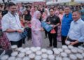 ZALIHA Mustafa mengagihkan bubur lambuk kepada pengunjung bazar ramadan pada Majlis Kongsi Rezeki Alam Flora bersama Perbadanan Putrajaya (PPJ) di Bazar Ramadan Presint 3, Putrajaya. - UTUSAN/FAIZ ALIF ZUBIR