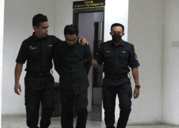 ANGGOTA polis membawa Ahmad Khairuddin Khalid (tengah) di Mahkamah Sesyen Kota Bharu, Kelantan. - UTUSAN/ROSALWANI CHE SOH