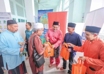 SHARIFUDIN Md Shaarani (tengah) dan Mohamad Azlan Jaafar (dua 
dari kanan) mengagihkan pek bubur lambuk kepada warga USIM pada 
Program Kongsi Berkat Bubur Lambuk di Nilai semalam.