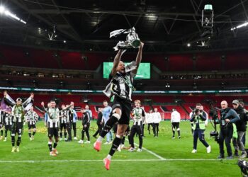 Pemain Newcastle United, Joelinton menjulang Piala Liga selepas pasukannya menewaskan Liverpool 2-1 dalam perlawanan akhir di Stadium Wembley, London. - AFP