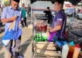 AFFENDI Rajini Kanth (kiri) menyerahkan apron kepada salah seorang peniaga semasa melakukan tinjauan di bazar Ramadan Kangar, Perlis, semalam.- UTUSAN/ASYRAF MUHAMMAD