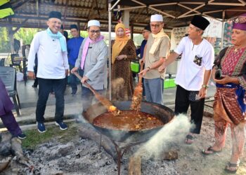 MOHD Hanafiah Man (dua dari kiri) bersama penduduk kampung mengacau gulai kawah pada Program Desa Cerdas Kampung Pulau Manis, Serada, Kuala Terengganu, semalam. - UTUSAN/PUQTRA HAIRRY