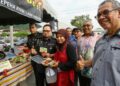 KAMALLUDDIN Ismail (kiri) pada Sesi Walkabout Bazar Ramadan Rahmah di Taman Cempaka di Ipoh hari ini. - UTUSAN/MUHAMAD NAZREEN SYAH MUSTHAFA