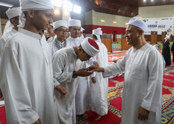 SAARANI Mohamad bersalaman dengan pelajar tahfiz pada majlis berbuka puasa di Laman Seri Ridzuan, di Ipoh, Perak. - UTUSAN