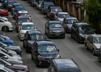 KAWASAN tempat letak kereta yang terhad menyebabkan kereta parkir di depan kereta lain.-GAMBAR HIASAN